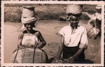 Front: Two Malagasy women fishing with bas...