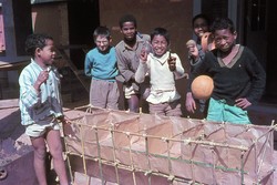 Kilasimandry [boarding] boys making a bamboo and brown paper model of the recently rebuilt girls' dormitory: Friends School, Soavinandriana