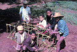 Kilasimandry [boarding] boys making a bamboo and brown paper model of the recently rebuilt girls' dormitory: Friends School, Soavinandriana